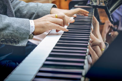 Midsection of man playing piano