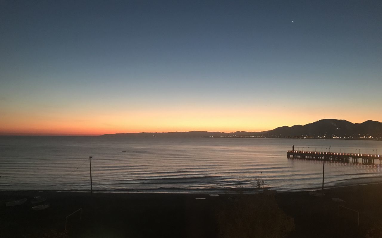 SCENIC VIEW OF SEA AGAINST CLEAR SKY AT SUNSET