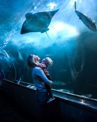 Woman in fish tank at aquarium