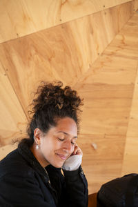 Happy latin woman smiling while sitting indoors.