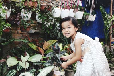 Portrait of smiling girl standing against plants