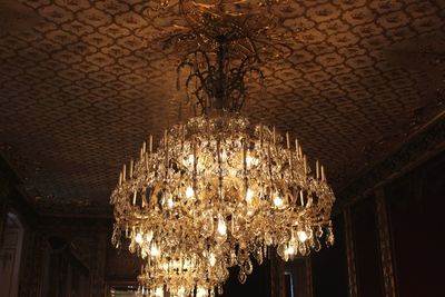 Low angle view of illuminated lighting equipment hanging at ceiling