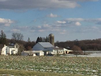 Houses by landscape against sky