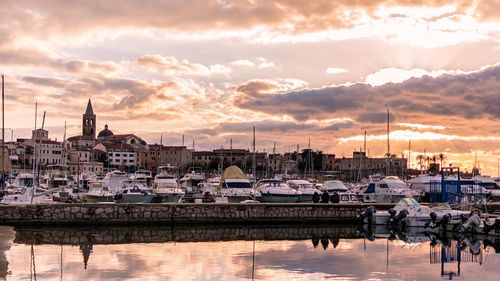 Boats moored at harbor during sunset