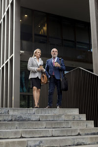 Senior businessman and businesswoman talking outside office building in the city