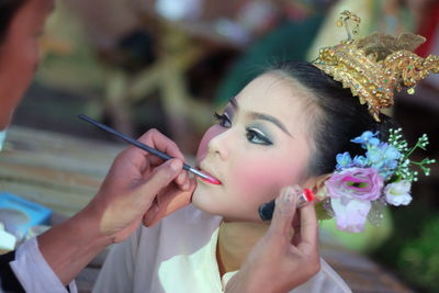 Cropped image of make-up artist applying lipstick to woman
