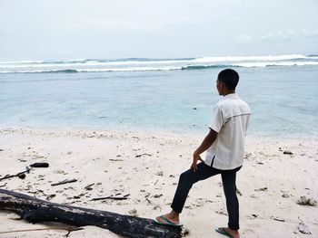 Rear view of man standing at beach