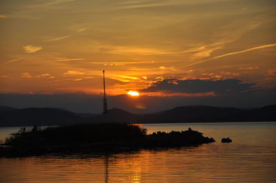 Silhouette lighthouse amidst lake balaton against sky