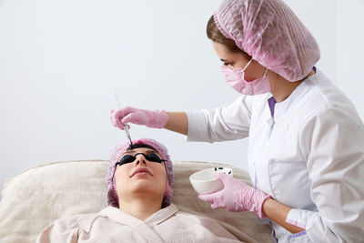 Portrait of female doctor examining patient