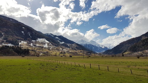 Scenic view of field and mountains against sky