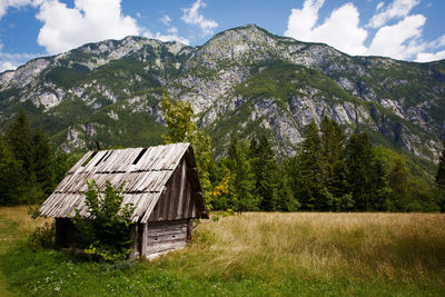 House on field against mountains