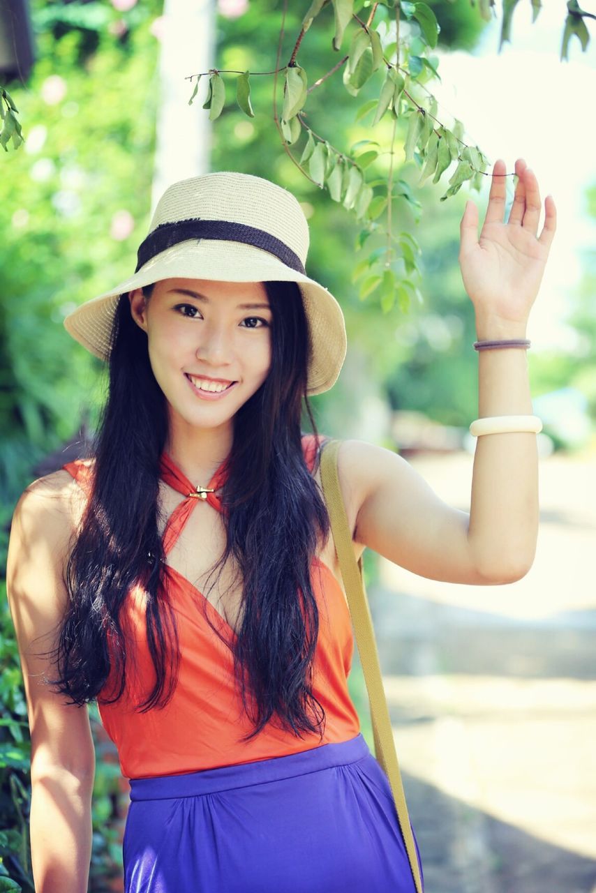 young adult, lifestyles, person, young women, leisure activity, long hair, looking at camera, portrait, casual clothing, smiling, front view, focus on foreground, happiness, standing, tree, sunglasses, waist up