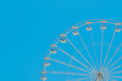 Wide low angle view of ferris wheel against clear blue sky