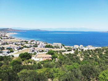 Scenic view of sea and buildings against clear sky