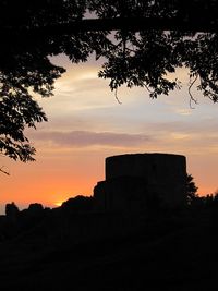 Silhouette of building against sky at sunset