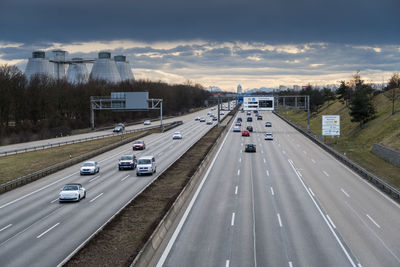 Cars on highway in city against sky