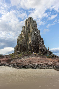 Rock formations by sea against sky