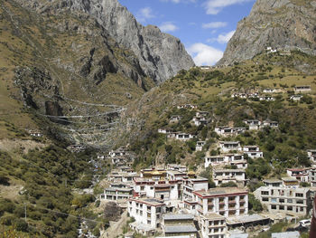 Aerial view of townscape by mountain against sky