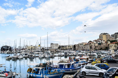 Sailboat moored at harbor against sky