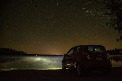 Man on car against sky at night