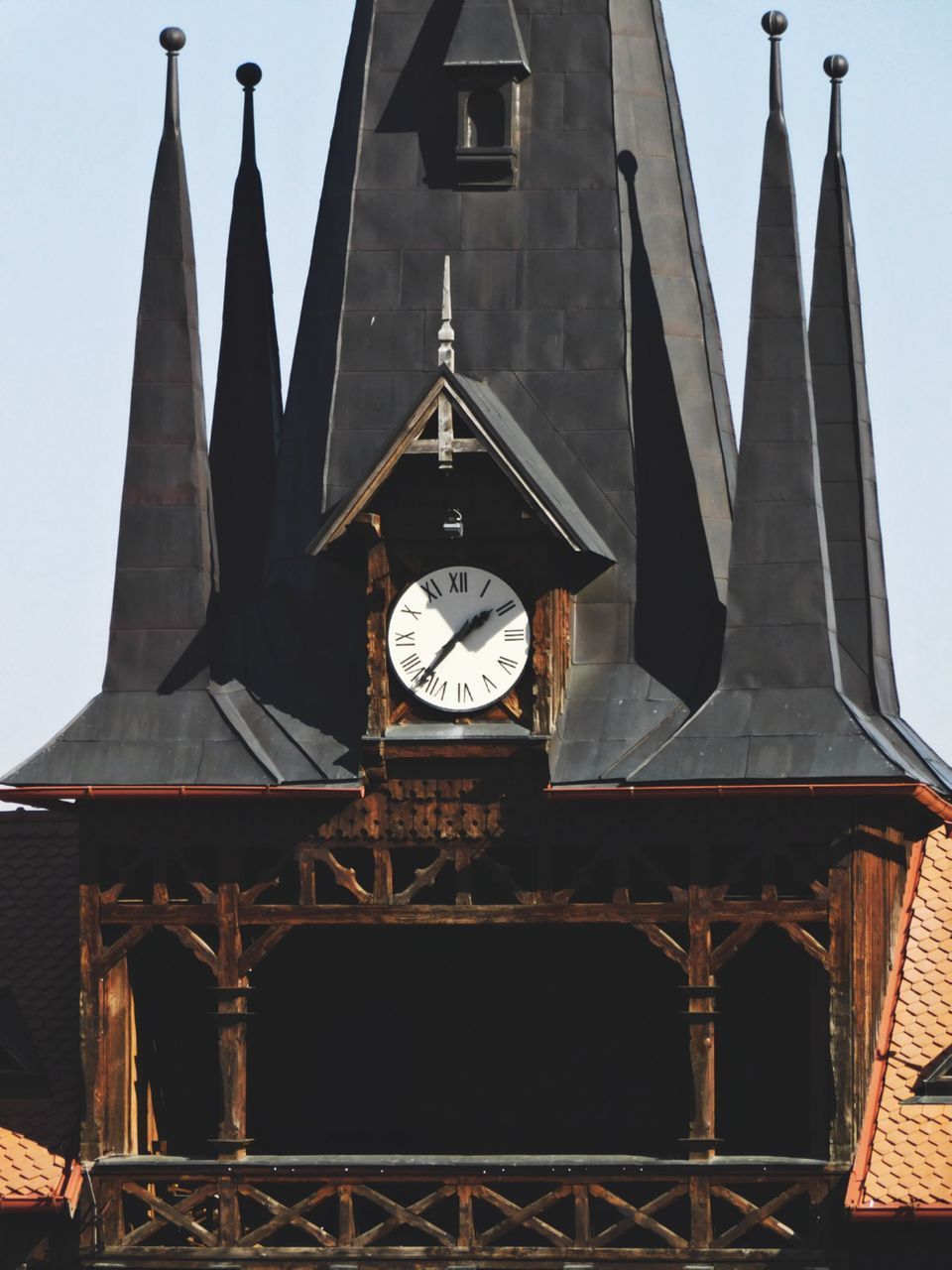 LOW ANGLE VIEW OF CLOCK TOWER AGAINST BUILDINGS