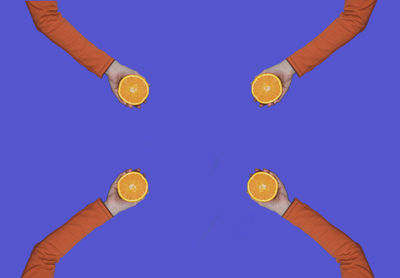 Close-up of hand holding ice cream against blue background