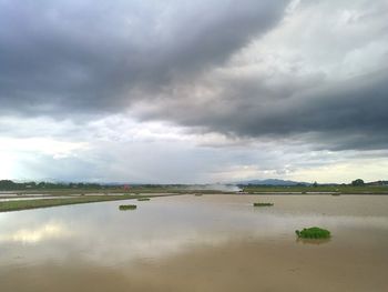 Scenic view of lake against storm clouds