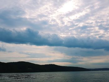 Scenic view of sea and mountains against sky