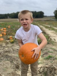 Boy looking away while standing on field