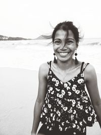 Portrait of smiling young man standing at beach