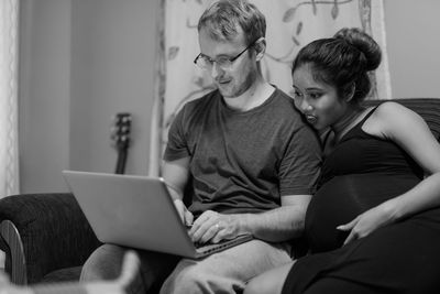 Friends sitting on sofa at home