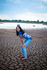 Full length portrait of young woman standing on beach