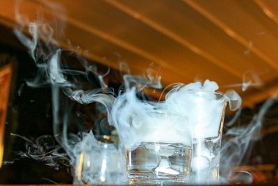Close-up of smoke emitting from drinking glasses
