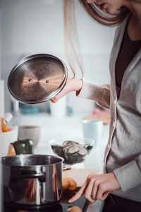 Midsection of woman cooking food in kitchen