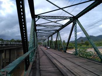 Footbridge over railroad tracks against sky