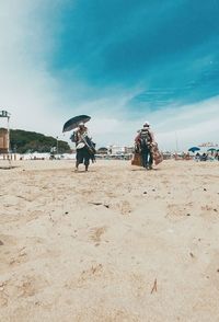 People at beach against sky