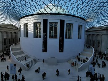 People on snow covered buildings in city