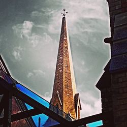 Low angle view of modern building against cloudy sky