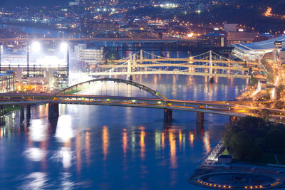 Illuminated bridge over river at night