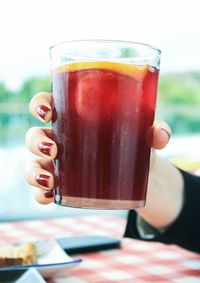 Close-up of cropped woman hand holding drink at restaurant