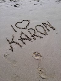 High angle view of text on sand at beach