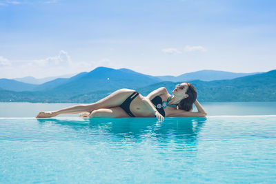 Woman in boat in swimming pool against sky