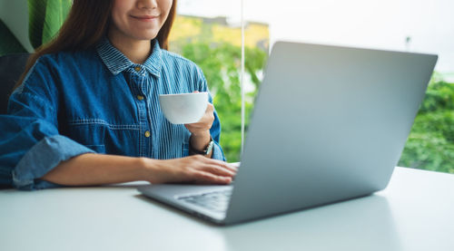 Young woman using laptop at table