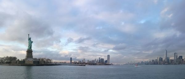 Statue of city against cloudy sky