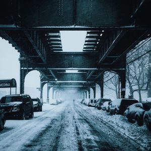 Cars parked under bridge on winter day