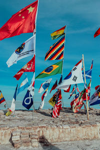 Low angle view of flags on beach against sky