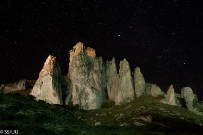 Low angle view of rocks against sky at night