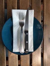 High angle view of empty plate with knife and fork on table