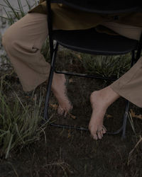 Low section of woman standing on field