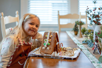 Portrait of girl with dessert on table at home